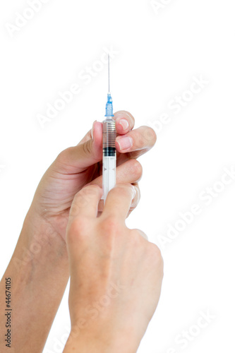 Photo: Syringe with a medicine in a female hands, isolated on white Syringe with a medicine in a female hands, isolated on white