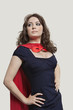 Beautiful woman in superhero costume over gray background