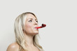 Young woman with party blower looking away over gray background