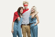 Photo: Portrait of young man in superhero costume and women wearing jumpsuits standing together against gray background Portrait of young man in superhero costume and women wearing jumpsuits standing together against gray background
