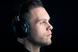 Photo: Close up profile of man with ear-phones on black background. Close up profile of man with ear-phones on black background.