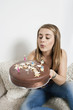 Young woman blowing out candles on birthday cake
