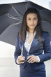 Portrait of a young Indian businesswoman holding umbrella