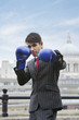 Foto: Indian businessman wearing blue boxing gloves with St. Paul's Cathedral in the background Indian businessman wearing blue boxing gloves with St. Paul's Cathedral in the background