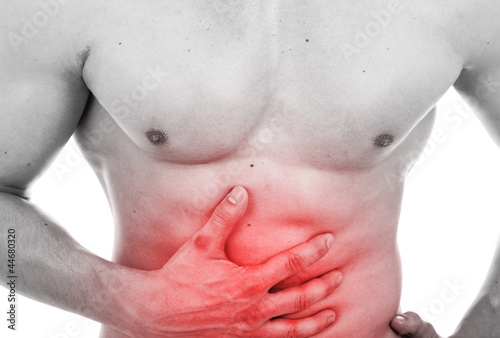 Photo: Muscular man with stomach pain, isolated on white Muscular man with stomach pain, isolated on white