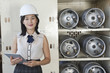 Photo: Portrait of female industrial worker holding tablet PC with cylinders on shelf in background Portrait of female industrial worker holding tablet PC with cylinders on shelf in background