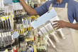 Photo: Midsection of male store clerk holding painting tools Midsection of male store clerk holding painting tools