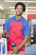 Photo: Portrait of an African American male store clerk standing at checkout counter Portrait of an African American male store clerk standing at checkout counter