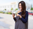 portrait of young woman touching a modern mobile at street