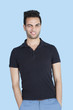 Portrait of mid adult man winking with hands in pockets over blue background