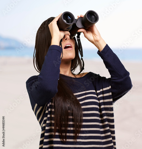 Photo: portrait of young woman looking through a binoculars against a b portrait of young woman looking through a binoculars against a b