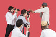 Young male celebrity shielding face from photographers over red background