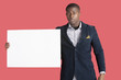 Photo : Portrait of a young smart man wearing coat with blank cardboard over pink background Portrait of a young smart man wearing coat with blank cardboard over pink background