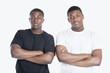 Photo: Portrait of two African American male friends with arms crossed over gray background Portrait of two African American male friends with arms crossed over gray background