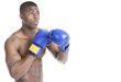 Photo: Young boxer wearing boxing gloves in fighting stance over gray background Young boxer wearing boxing gloves in fighting stance over gray background