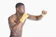 Photo: African American male boxer kickboxing over gray background African American male boxer kickboxing over gray background