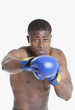 Photo: Portrait of an African American boxer punching over gray background Portrait of an African American boxer punching over gray background