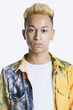 Portrait of a trendy teenage boy with unbuttoned shirt over gray background