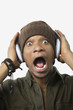Photo: Portrait of a surprised young African American man listening music through headphones Portrait of a surprised young African American man listening music through headphones
