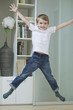 Portrait of a boy in casuals jumping in mid-air at home