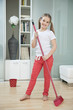 Portrait of a young girl sweeping floor with broom