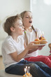 Siblings blowing candles on cupcakes