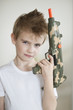 Side view of a young boy holding toy gun
