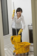Foto: Portrait of young maidservant with mop Portrait of young maidservant with mop