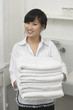 Portrait of beautiful housemaid holding white towels