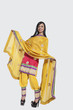 Photo: Full length of an Indian woman in salwar kameez standing over gray background Full length of an Indian woman in salwar kameez standing over gray background