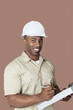 Photo: Portrait of happy young African male construction worker holding clipboard over brown background Portrait of happy young African male construction worker holding clipboard over brown background