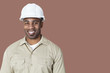 Photo: Portrait of happy young construction worker with hardhat over brown background Portrait of happy young construction worker with hardhat over brown background
