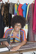 Photo: Portrait of an African American female tailor stitching cloth on sewing machine Portrait of an African American female tailor stitching cloth on sewing machine