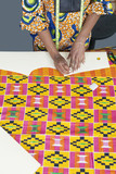 Photo : Midsection of female fashion designer marking pattern with chalk on fabric textile Midsection of female fashion designer marking pattern with chalk on fabric textile