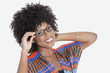 Photo: Portrait of young woman in African print attire wearing glasses over gray background Portrait of young woman in African print attire wearing glasses over gray background
