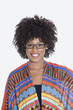 Photo: Portrait of young woman in African print attire standing over gray background Portrait of young woman in African print attire standing over gray background