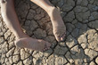 Low section of a woman lying on cracked land