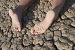 Low section of a woman lying on cracked land