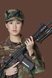 Photo: Portrait of beautiful young US Marine Corps soldier with M4 assault rifle over brown background Portrait of beautiful young US Marine Corps soldier with M4 assault rifle over brown background