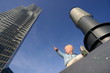 Kleiner Junge sitzt vor einem Schornstein vor blauem Himmel