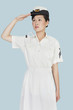 Beautiful young US Navy officer saluting over light blue background