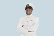 Foto: Portrait of a happy young US Navy officer with arms crossed over light blue background Portrait of a happy young US Navy officer with arms crossed over light blue background