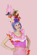Portrait of beautiful young woman in Brazilian outfit over pink background