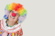 Foto: Happy senior clown looking up against gray background Happy senior clown looking up against gray background