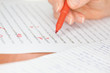 Hand with Red Pen Transcribing a Story