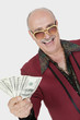 Foto: Portrait of happy senior man showing US banknotes against gray background Portrait of happy senior man showing US banknotes against gray background