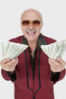 Foto: Portrait of cheerful senior man with US banknotes against gray background Portrait of cheerful senior man with US banknotes against gray background
