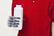 Photo: Mid section of a man holding bottle with prosthetic hand over gray background Mid section of a man holding bottle with prosthetic hand over gray background