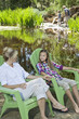 Photo: Mother and daughter relaxing on chairs with man and boy fishing in the background Mother and daughter relaxing on chairs with man and boy fishing in the background