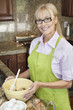 Portrait of a happy senior woman preparing food in kitchen